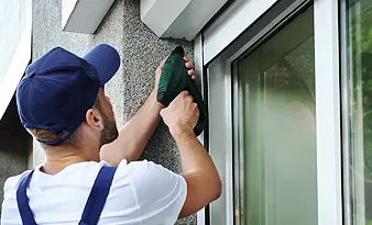 Redőny javítása panelház ablakán Budapesten, redőnyös szakember kézi szerszámmal dolgozik