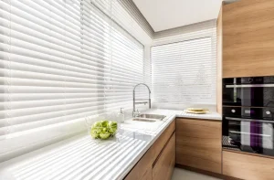 Fehér műanyag redőny szerelése budapesti konyhában, modern árnyékolási megoldás világos enteriőrben.